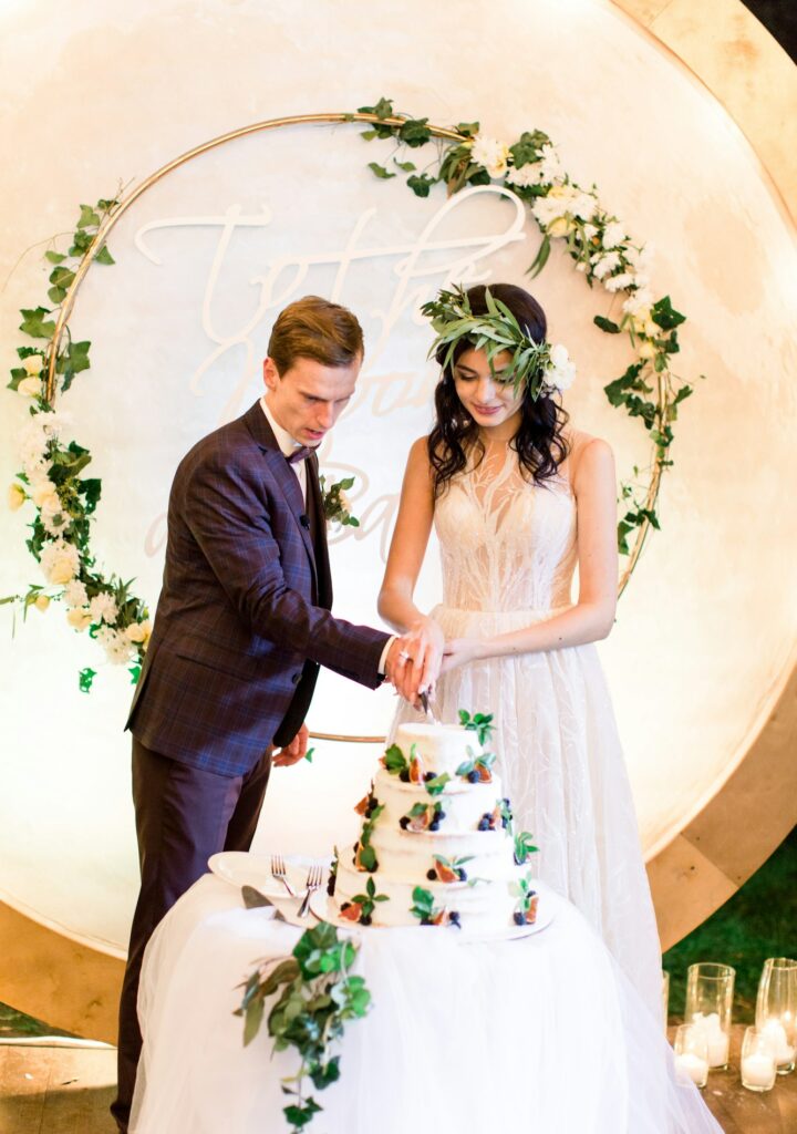 bride and groom cutting their rustic wedding cake. beautiful wedding cake. wedding reception